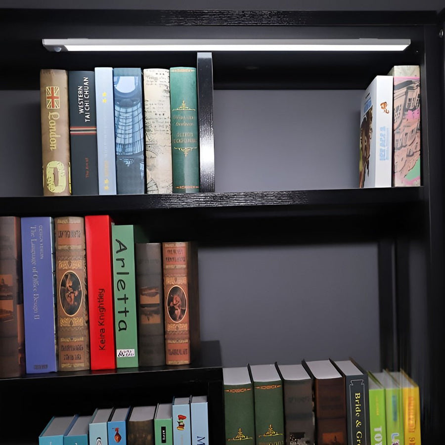 Bookshelf illumination using easy-to-install rechargeable wireless under cabinet lighting to highlight book titles.