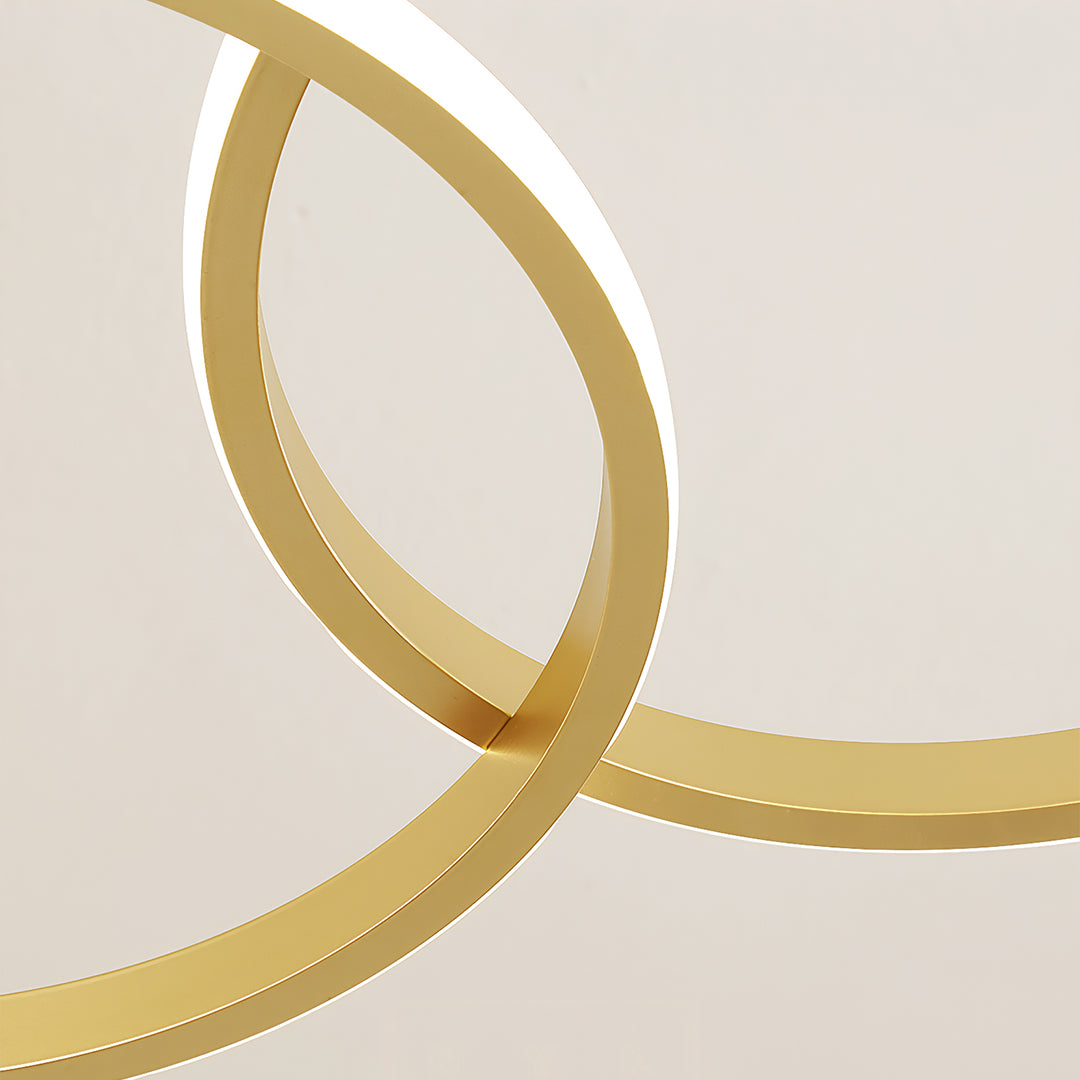 Artistic close-up of a gold chandelier lamp with two interconnected rings, elegant lighting design