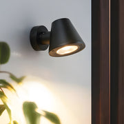 Interior accent lighting fixture with adjustable head creating focused illumination in modern space