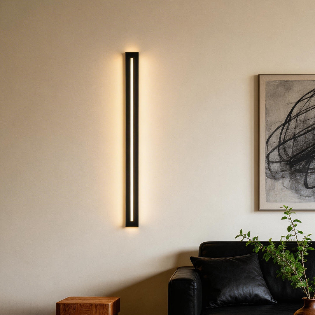 Contemporary interior lighting featuring linear long black wall sconces above a sofa.