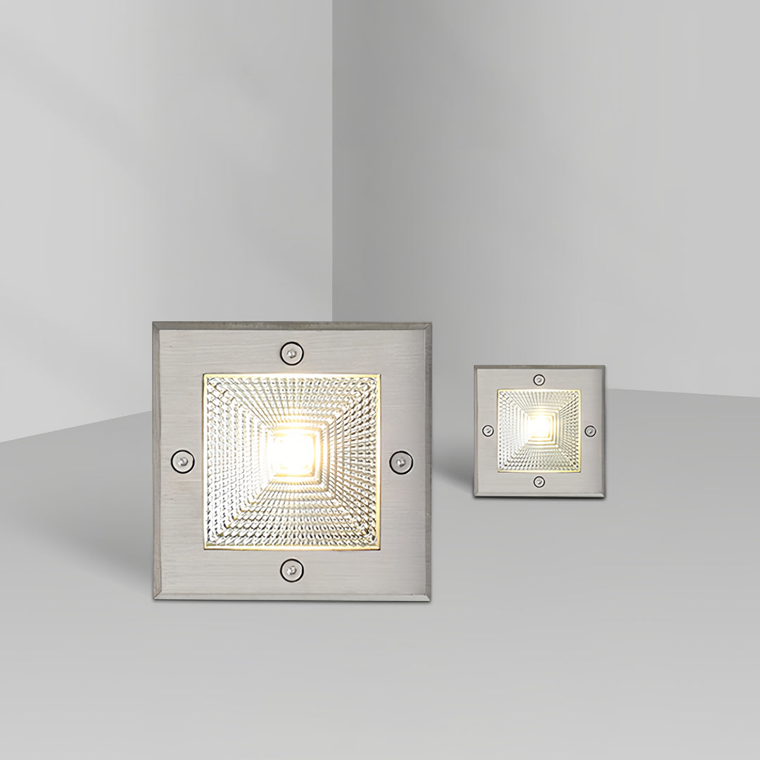 Modern square outdoor inground lighting installed in a minimal interior-style setting with warm glow.