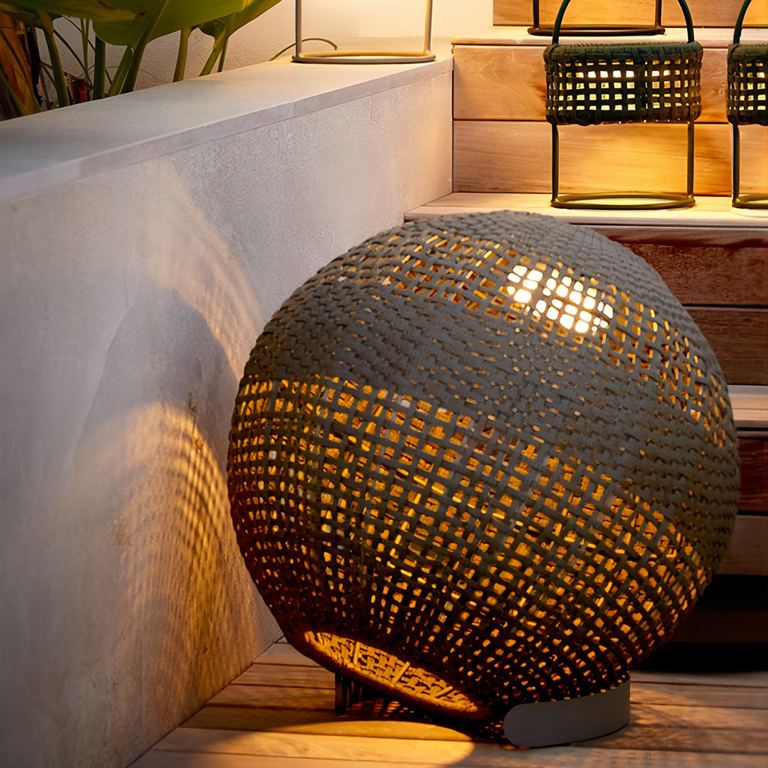 Close-up of the outdoor globe lantern, showing the intricate brown weaving and the warm light filtering through the weave pattern.