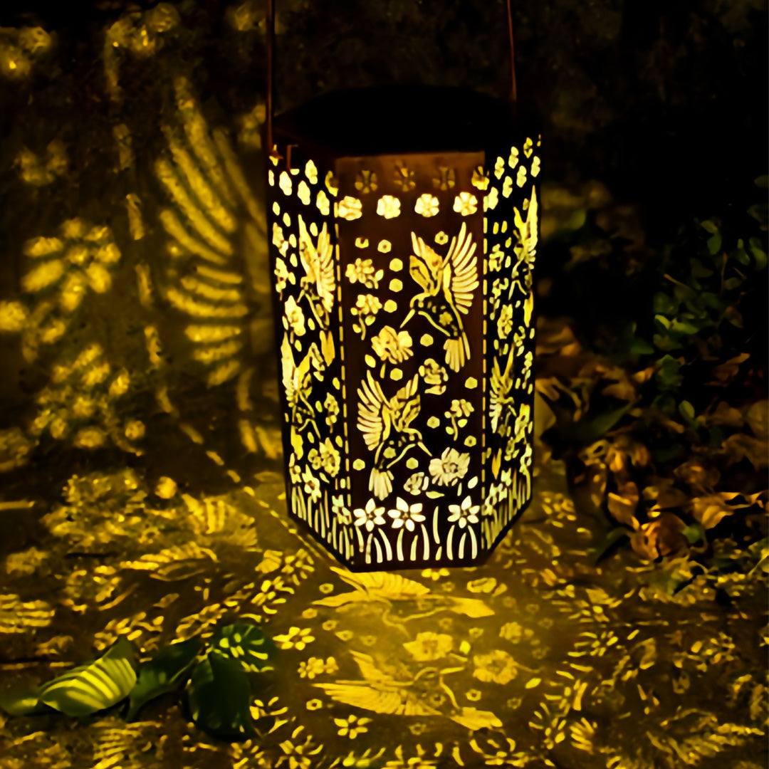 Intricate shadow patterns cast by a red outdoor lantern with garden flowers and butterfly designs at night.