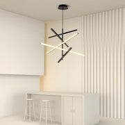 Iron linear chandelier installed in minimalist beige room with white furniture and wood accent wall.