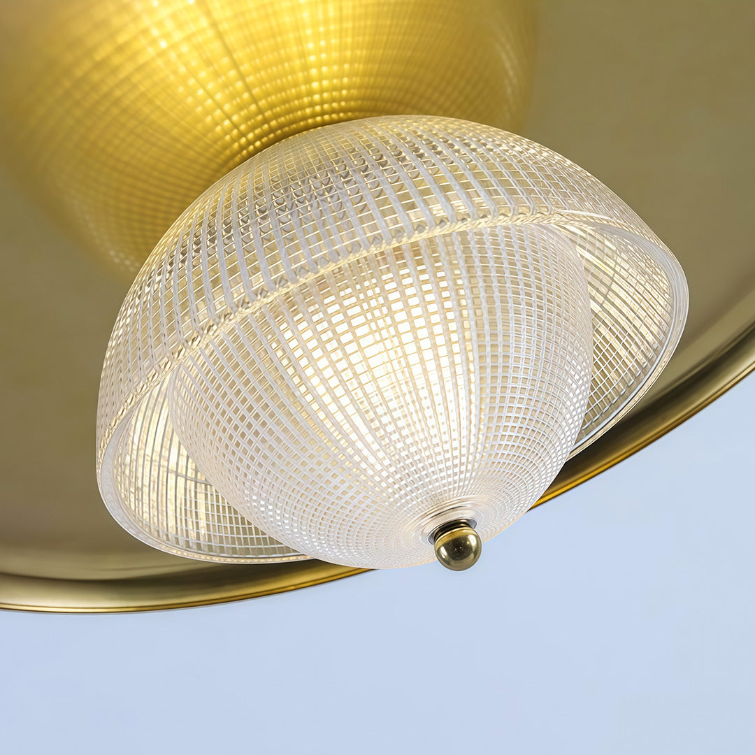 Bottom view of iron pendant light fixture revealing textured prismatic glass shade and brass trim details