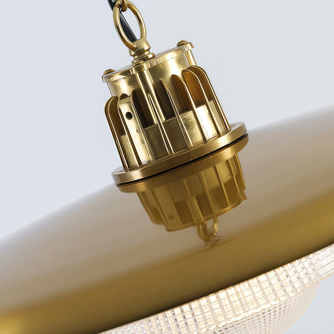 Close-up detail of iron pendant light fixture showing decorative brass hardware and ornamental chain mounting