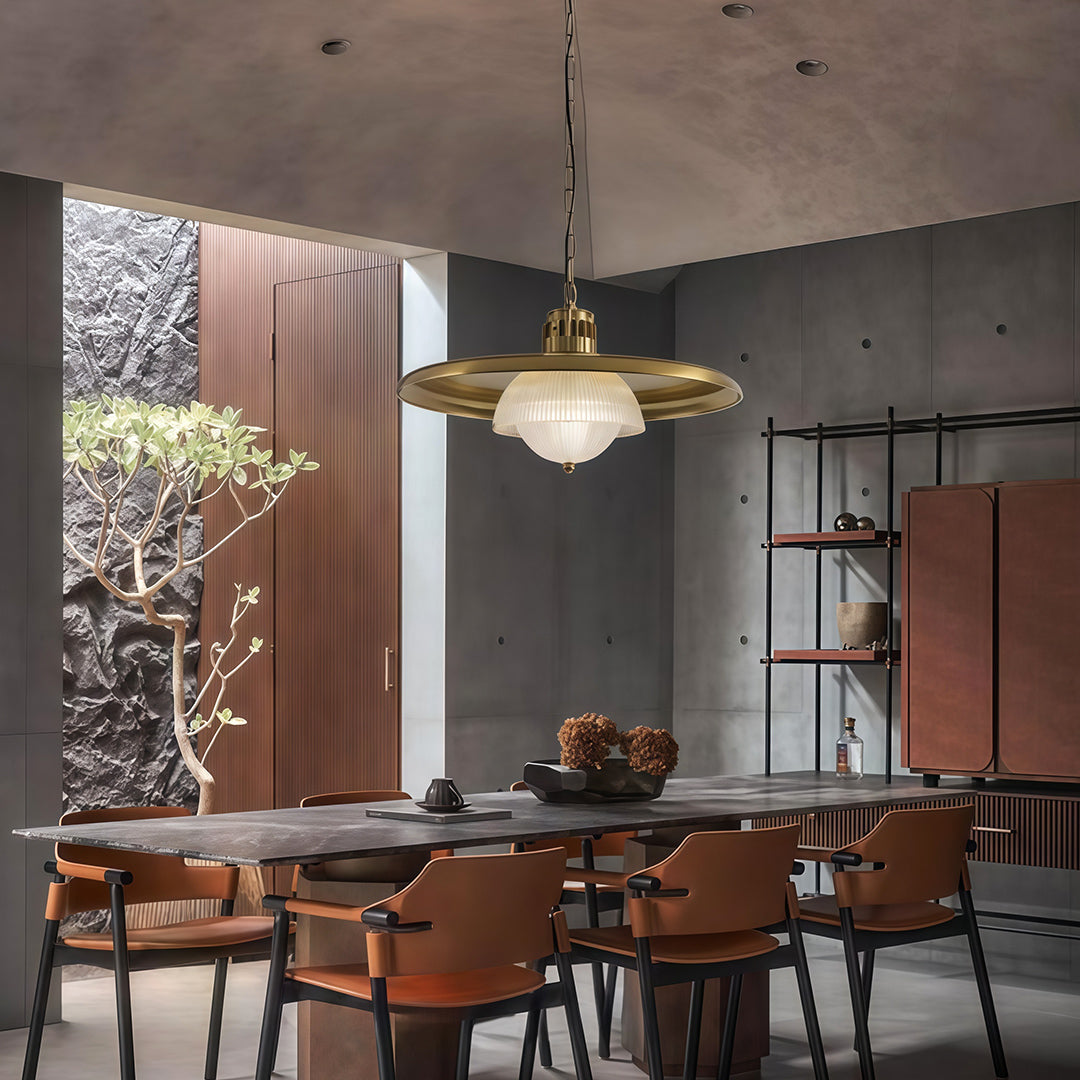 Iron pendant light fixture with ribbed glass shade hanging in modern dining room with dark accent wall