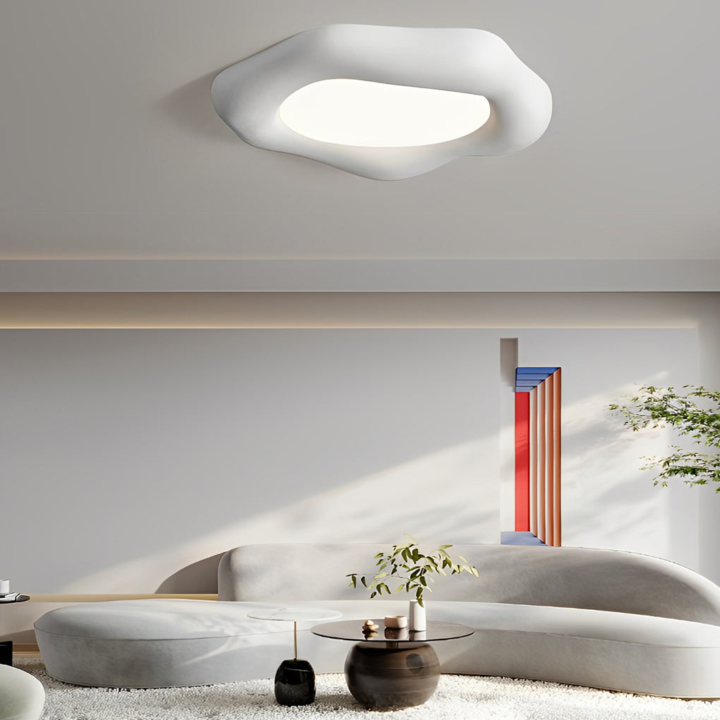 White irregular ceiling light providing soft illumination in a contemporary living room with curved sofas.