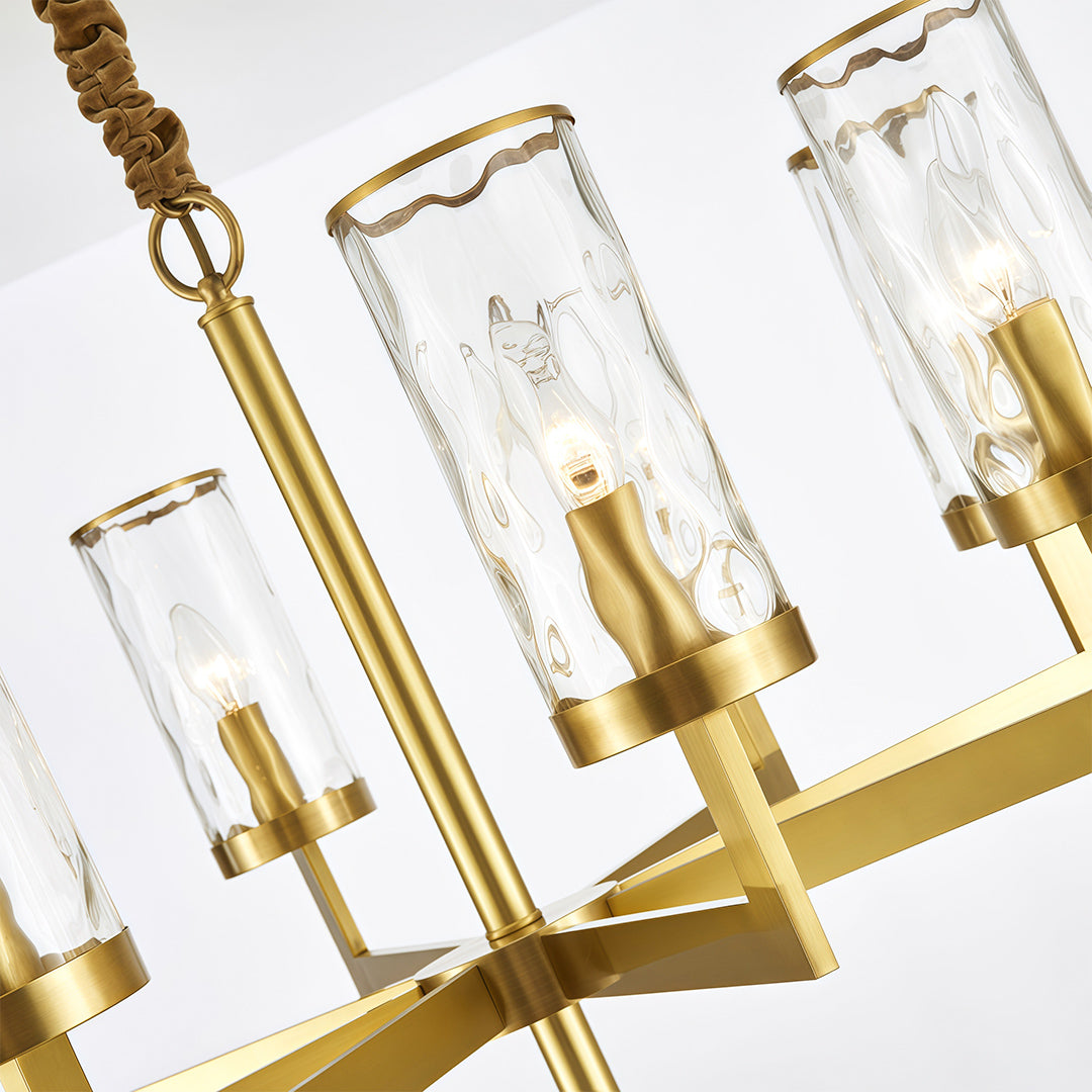 Modern luxury chandeliers close-up detail showcasing brass arms and cylindrical glass construction