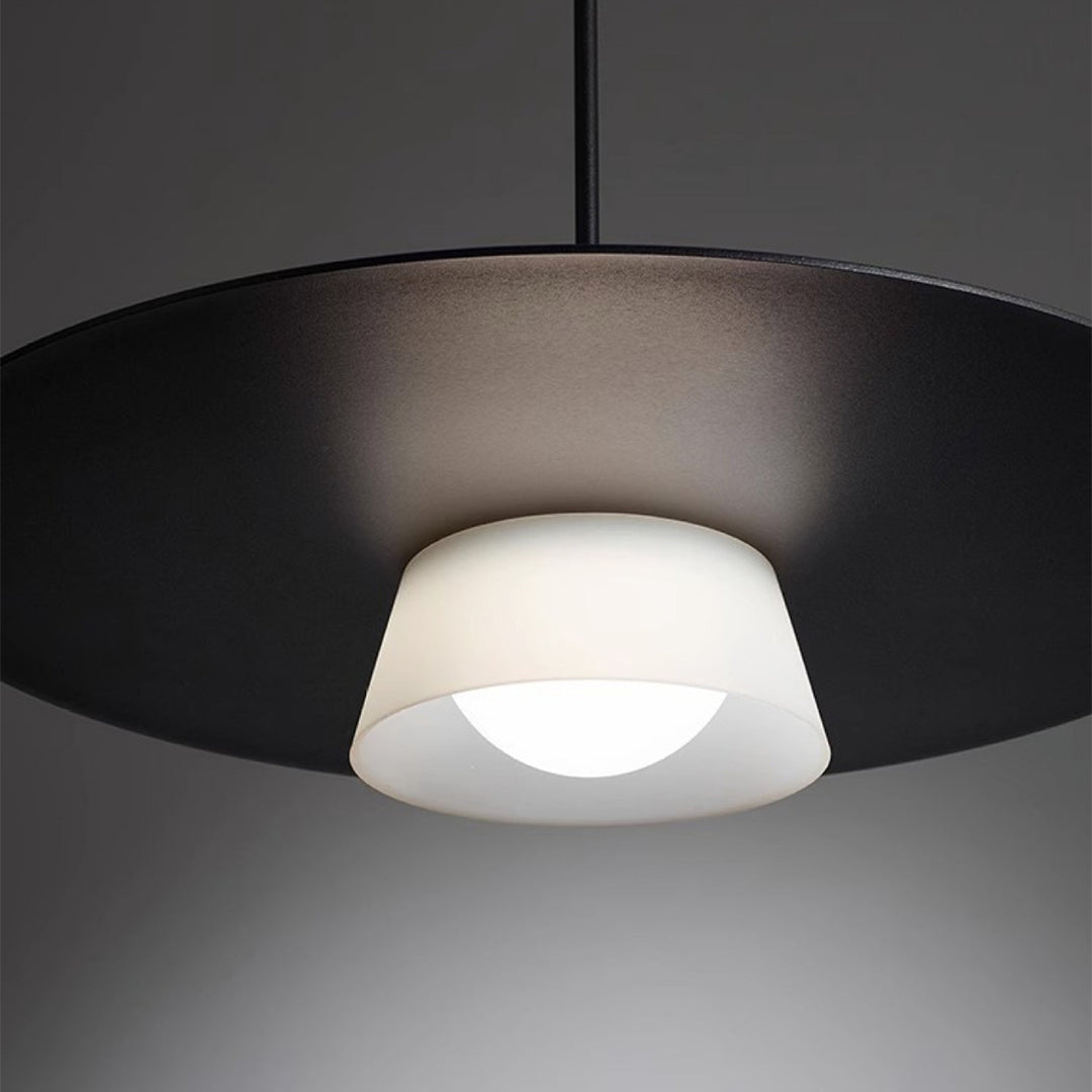 Close-up detail of island pendant light fixtures showing sleek disc design and warm illumination