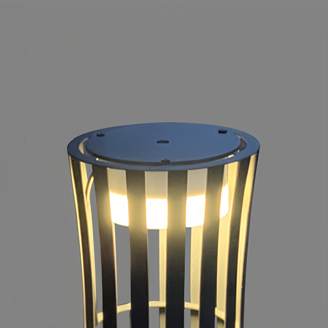 Isolated macro detail of the light source within the cage of the outdoor black lanterns, showing the diffused glow.