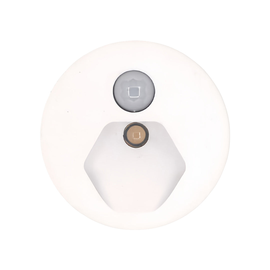 Isolated product detail of the interior stair step lights, showing the integrated motion sensor and the small, hexagonal white lens for effective, energy-efficient illumination.