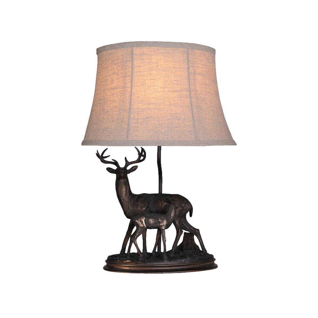 Isolated view of the deer table lamp, highlighting the textured resin base and the soft, ambient light from the bell-shaped shade.