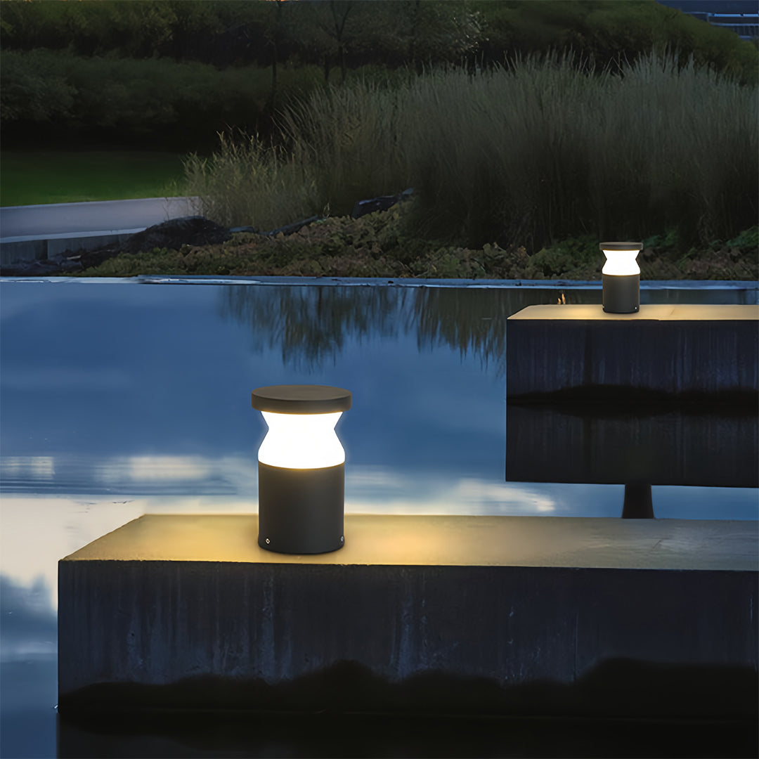 Isolated view of the modern path lights design, showcasing the dark grey body and round white light diffuser top.