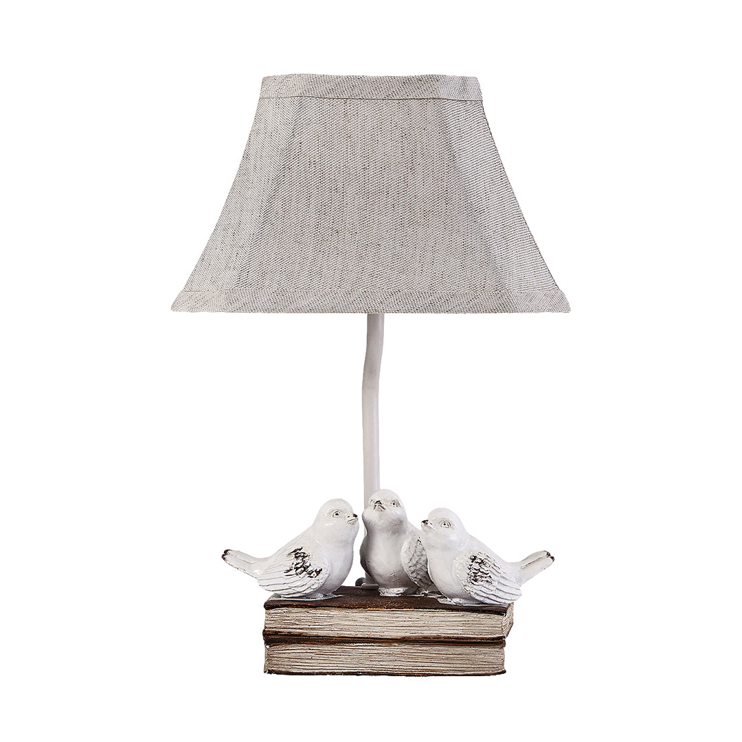 Isolated product view of the white small bird table lamp with a textured shade and rustic bird group base.