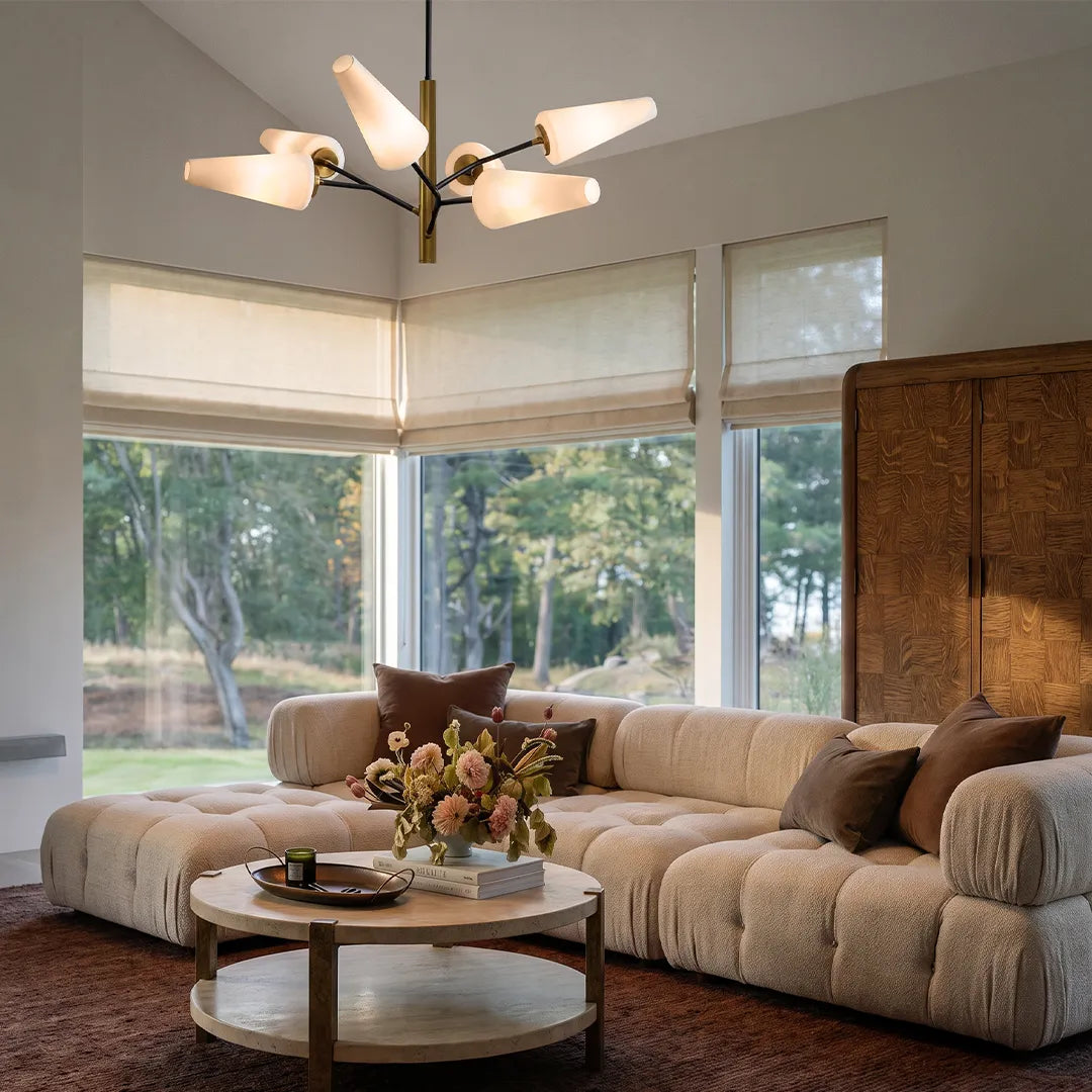 Italian glass chandelier installed above a curved sectional sofa in a bright contemporary living room.