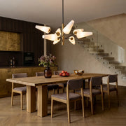 Italian glass chandelier hanging above a wooden dining table in a modern dining room with warm neutral tones.