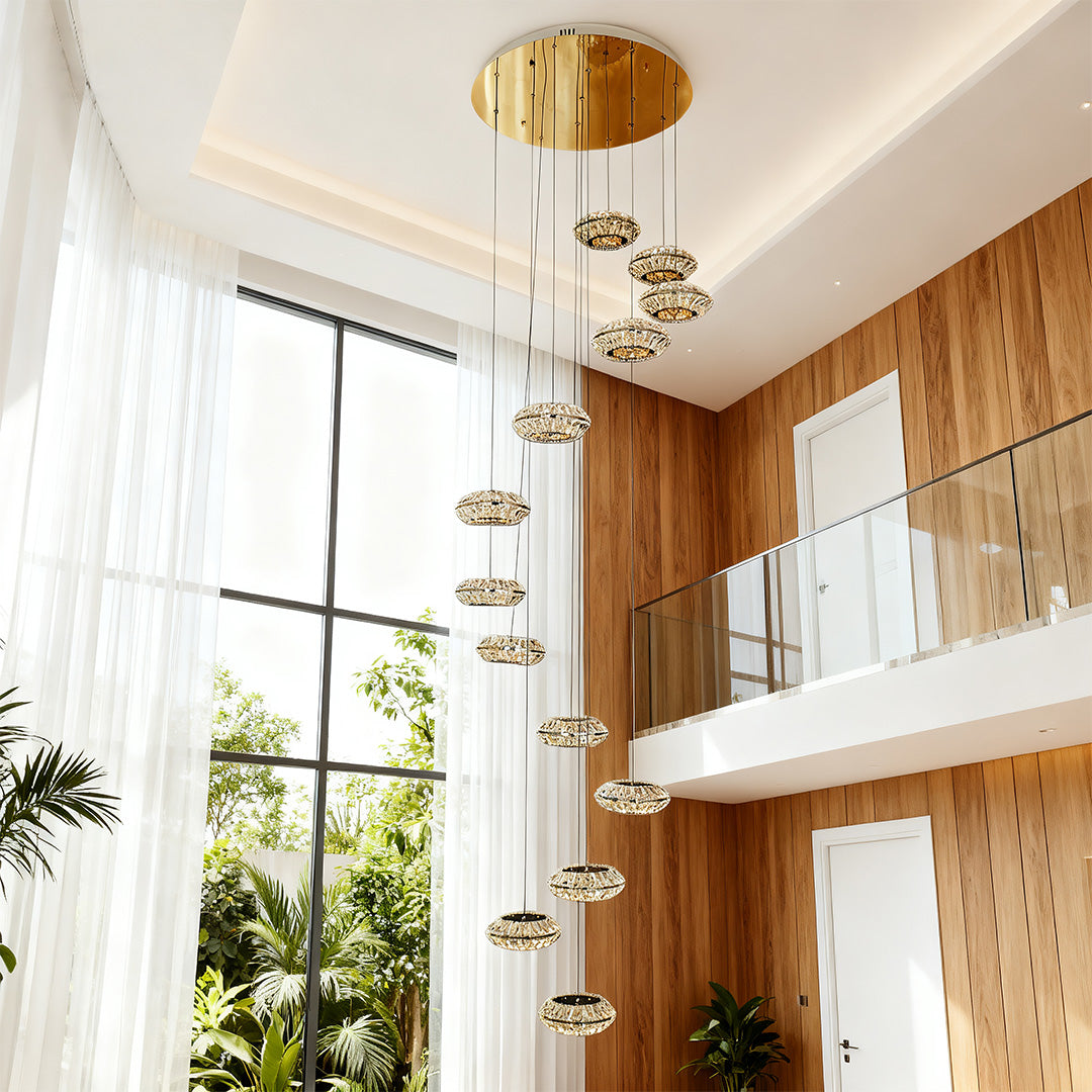 Italian style chandelier hanging in a luxurious living room with large windows and indoor plants.