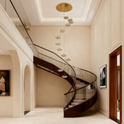 Italian style chandelier hanging above a spiral staircase, providing sophisticated illumination.