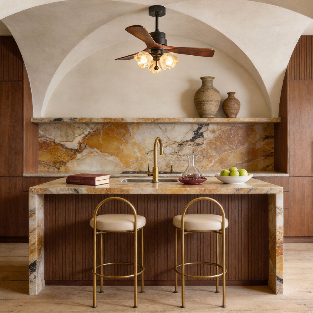 Ceiling fan with LED lighting installed above a warm wood kitchen island with decorative glass shades.