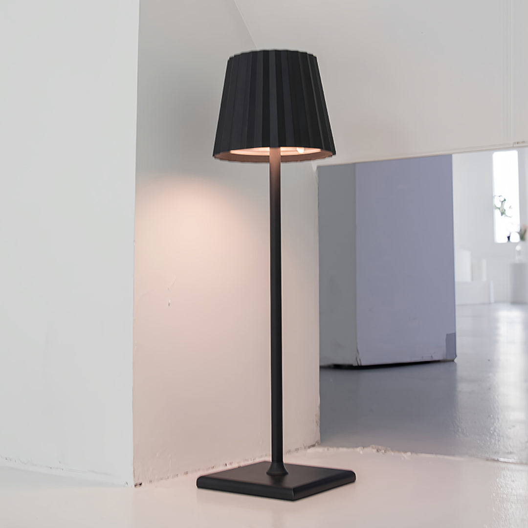 Modern metal table lamp positioned on kitchen counter providing task lighting for culinary workspace