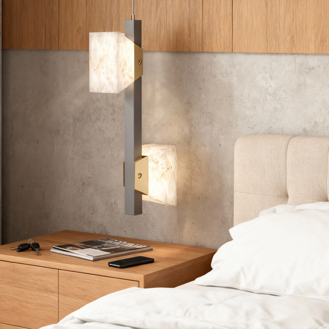 Linear kitchen island chandelier modern design above a dining table, featuring glowing stone-textured shades.