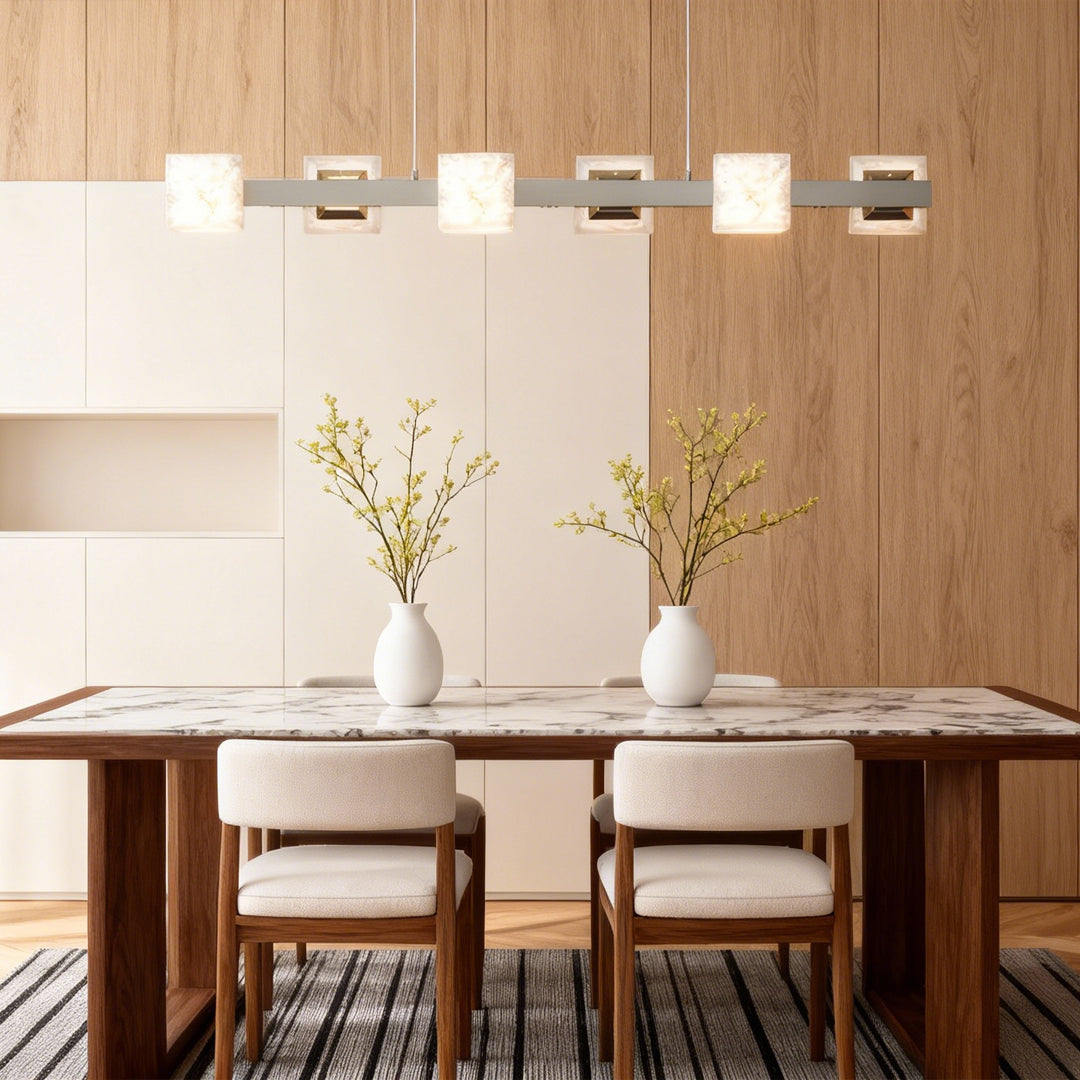 Warm dining room with a modern kitchen island chandelier featuring stone-textured shades and gold accents.