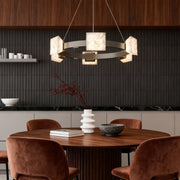 Elegant dining space illuminated by a modern kitchen island chandelier with stone cube lighting elements.