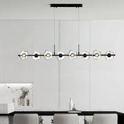 Sophisticated linear pendant chandelier illuminating modern kitchen island with black frame and crystal glass elements