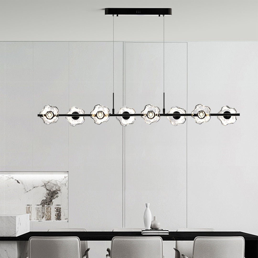 Sophisticated linear pendant chandelier illuminating modern kitchen island with black frame and crystal glass elements