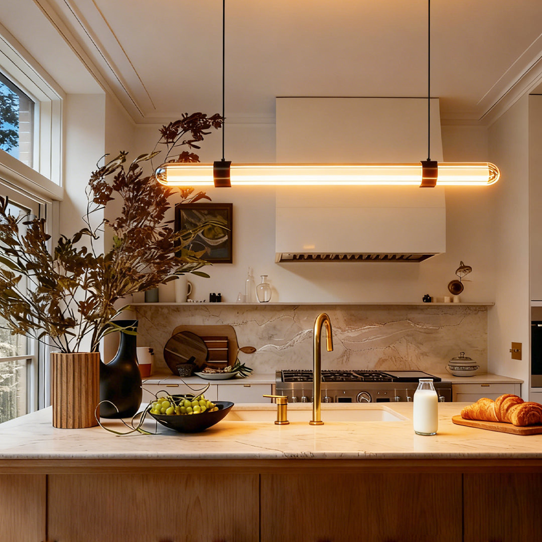 Warm kitchen interior illuminated by a modern linear suspension lighting bar above the island.