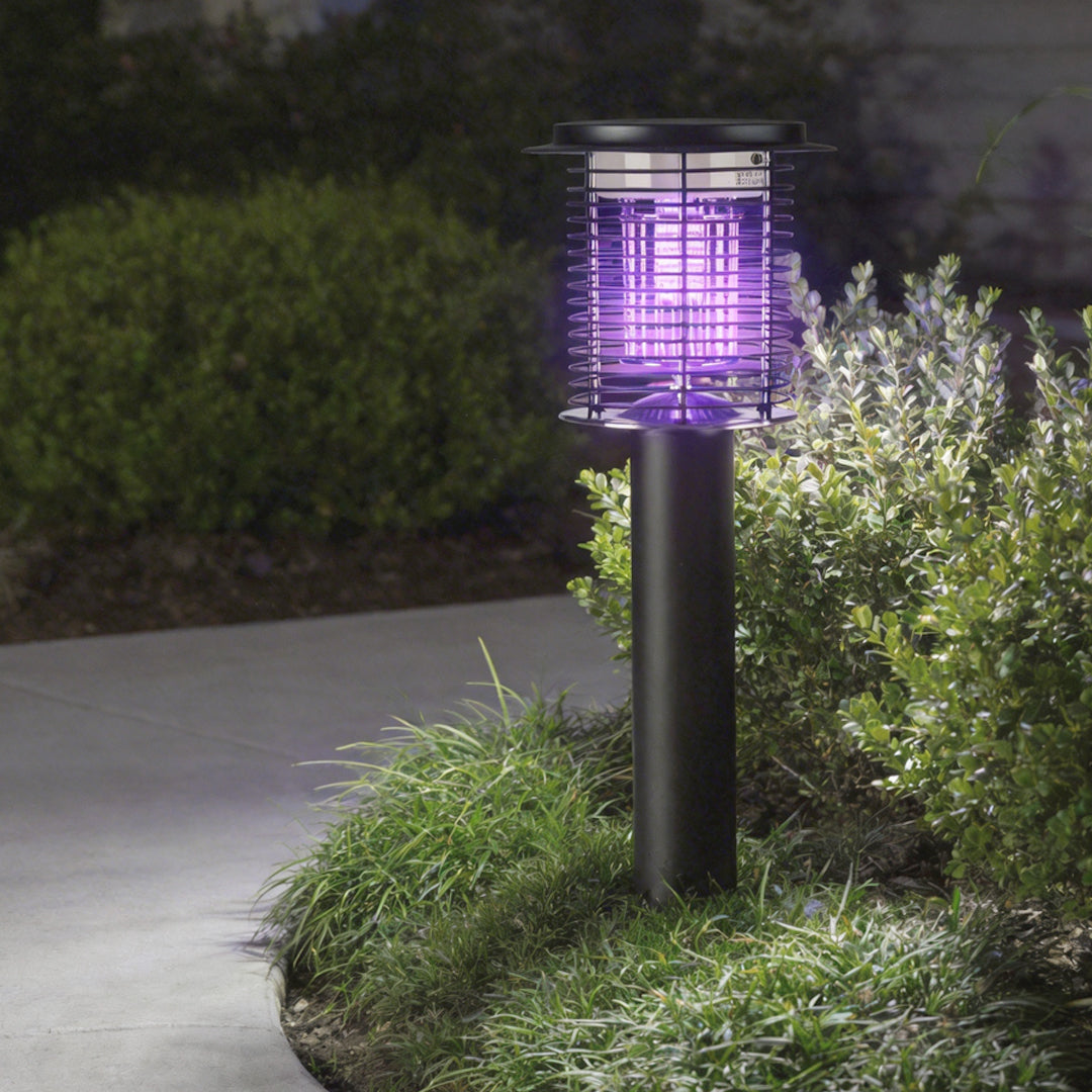 Lampara mata mosquitos with a modern design, illuminating a pathway with purple UV light.