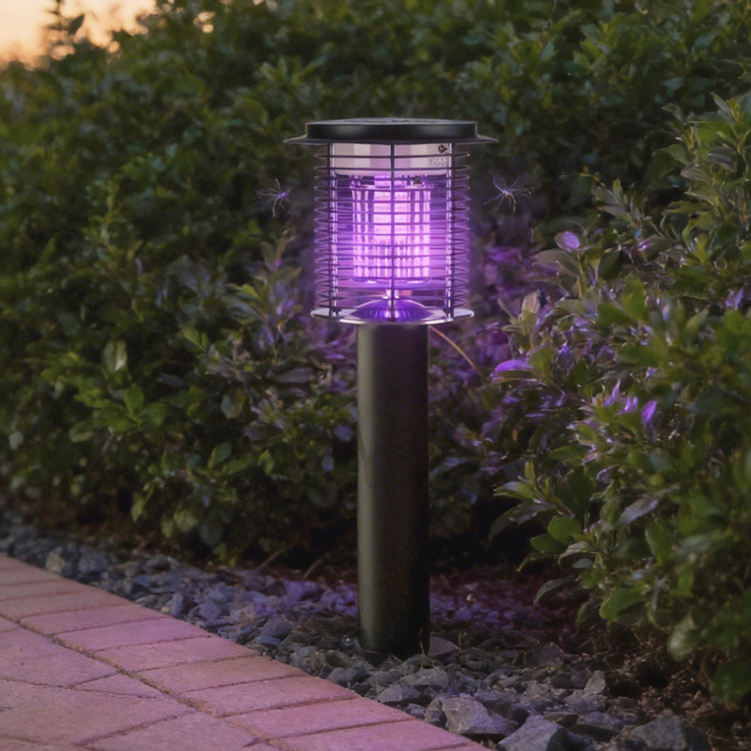 Lampara mata mosquitos with a sleek black design, providing purple UV light in a garden setting.
