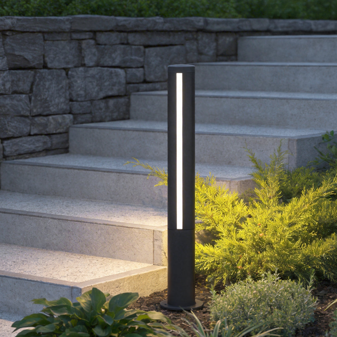 Landscape bollard lamp enhancing a contemporary outdoor staircase with warm glow.