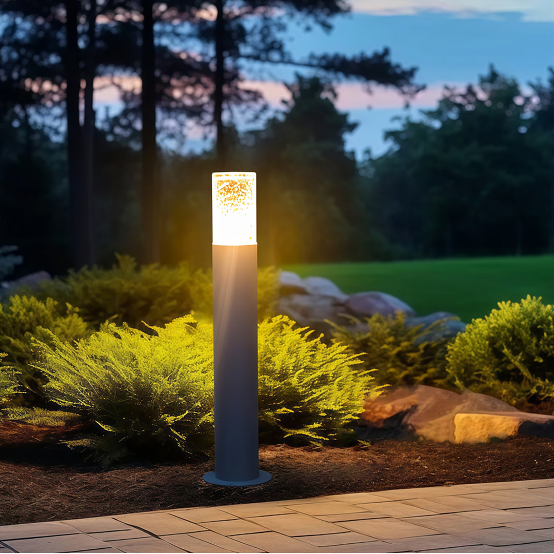 Landscape bollard light fixtures placed along a landscaped walkway, creating warm ambient outdoor lighting.