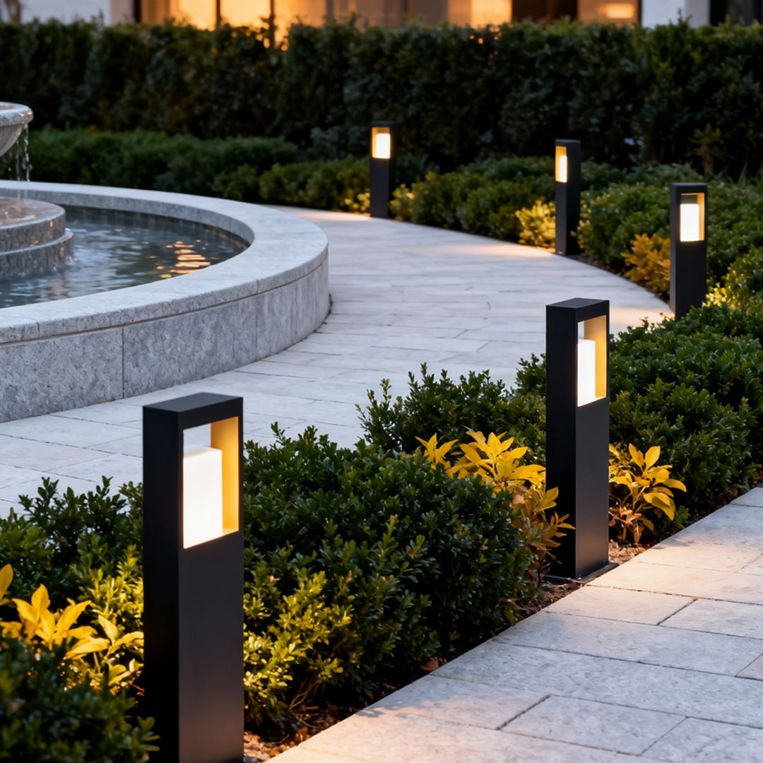 Landscape bollard lighting installed beside curved garden paths, creating warm ambient outdoor illumination.