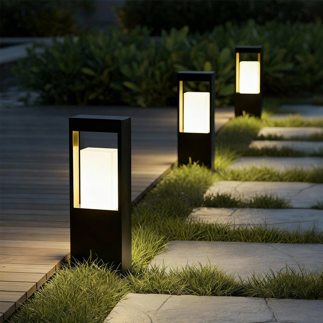 Pathway landscape bollard lighting illuminating a walkway with a modern rectangular light column.