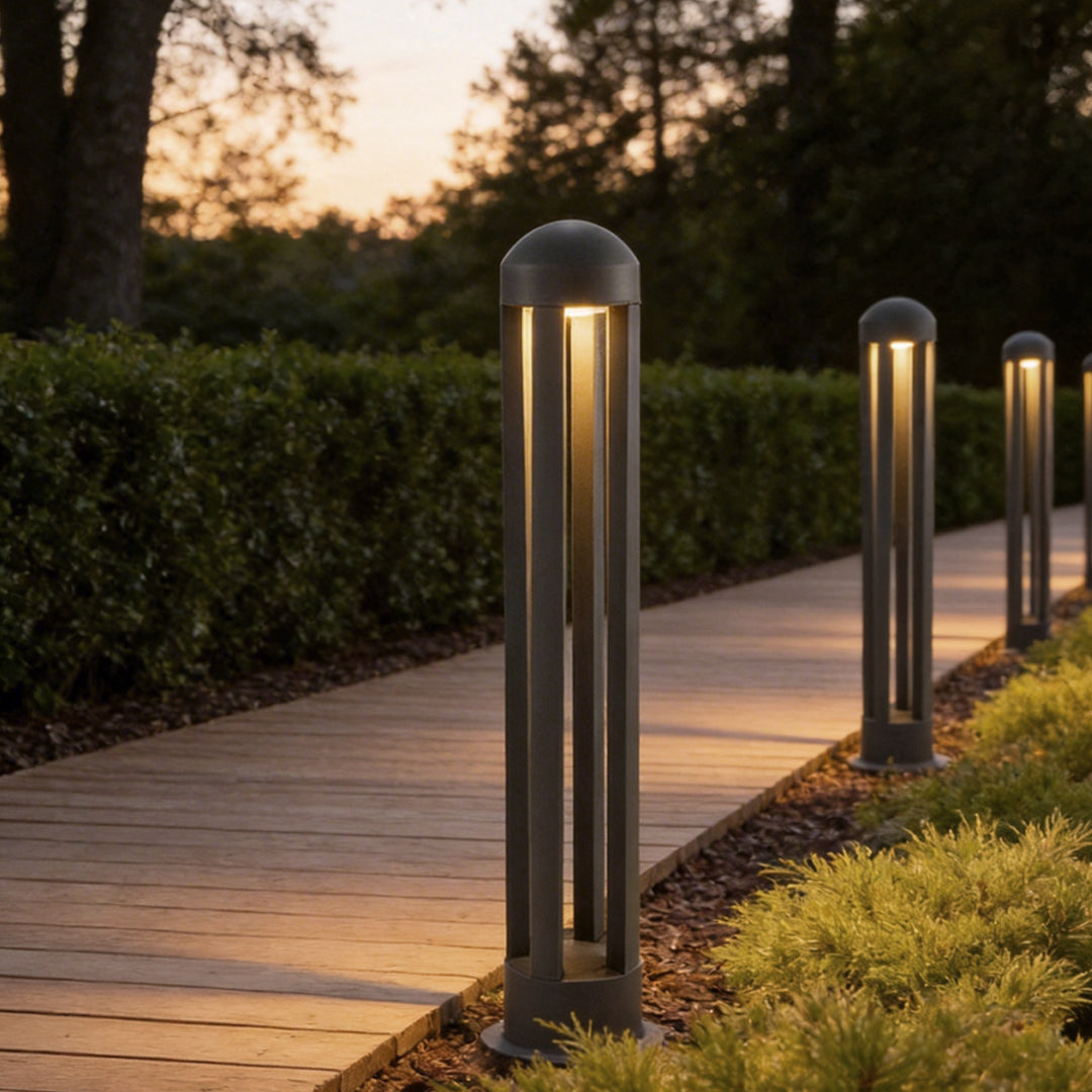 Landscape bollard lights illuminating a modern garden pathway with elegant vertical glow.