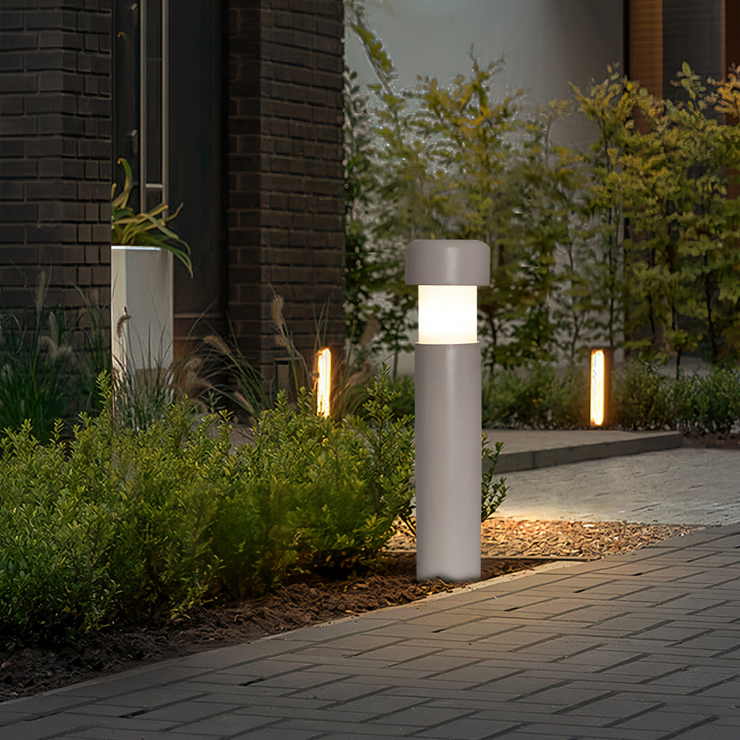 Modern landscape lighting bollards lighting up a contemporary home entrance with soft warm light.