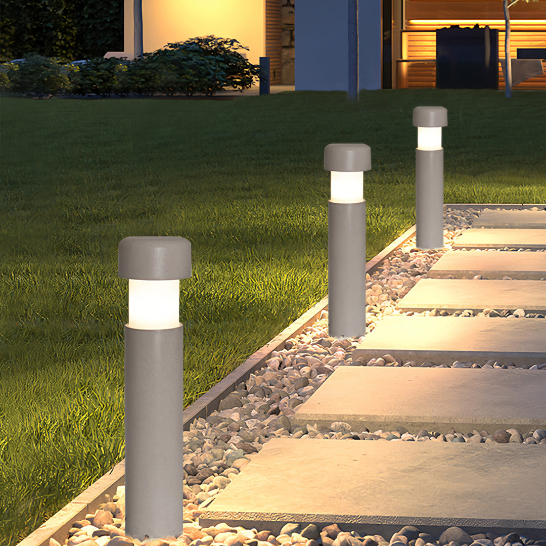 Landscape lighting bollards illuminating a modern stepping-stone walkway at dusk with bright, even light.