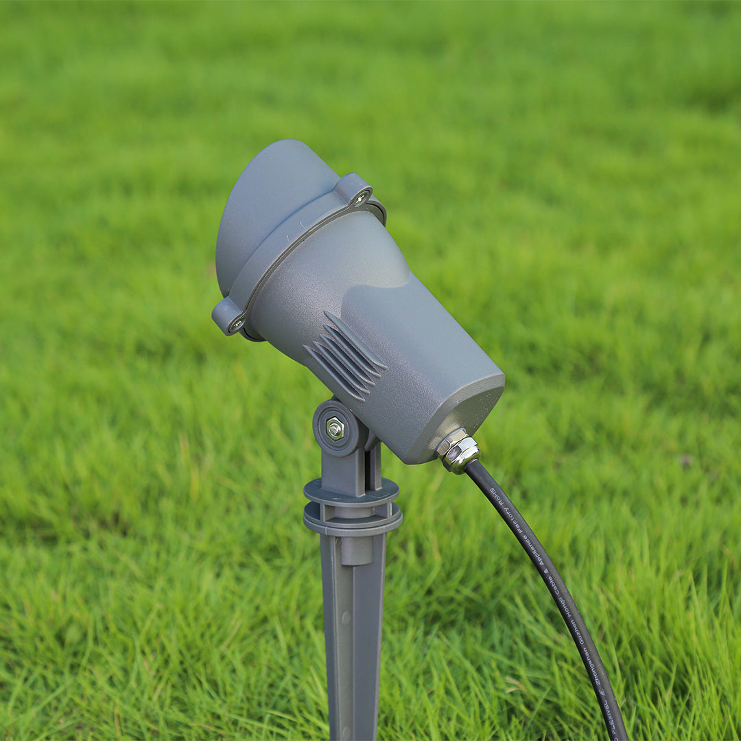 Landscape lighting creating dramatic uplighting on garden plants and modern building facade at night