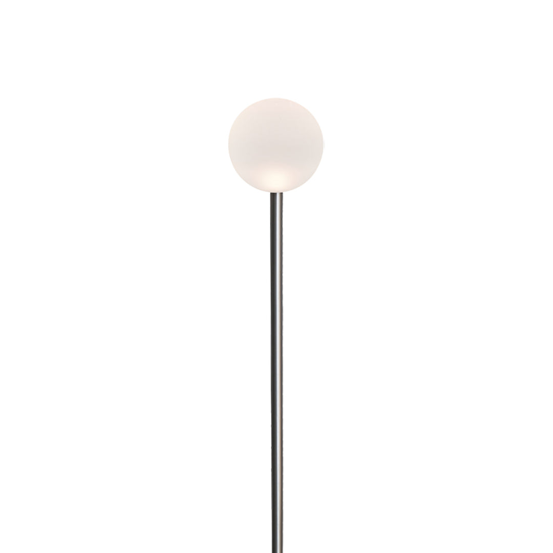 A compact white globe mounted on a tall thin pole, suitable for subtle and elegant landscape lighting pathway accents in gardens.