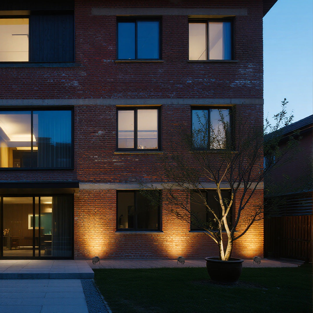 Landscape outdoor LED garden spotlights highlighting ornamental tree in modern courtyard setting