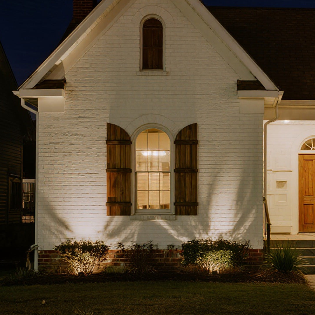 Landscape outdoor lighting LED spotlights highlighting white house exterior with focused beam projection