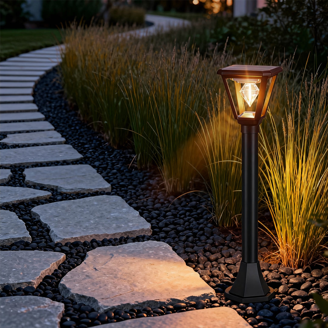 Elegant pathway lined with led post cap lights casting warm light onto landscaped stones and garden plants.
