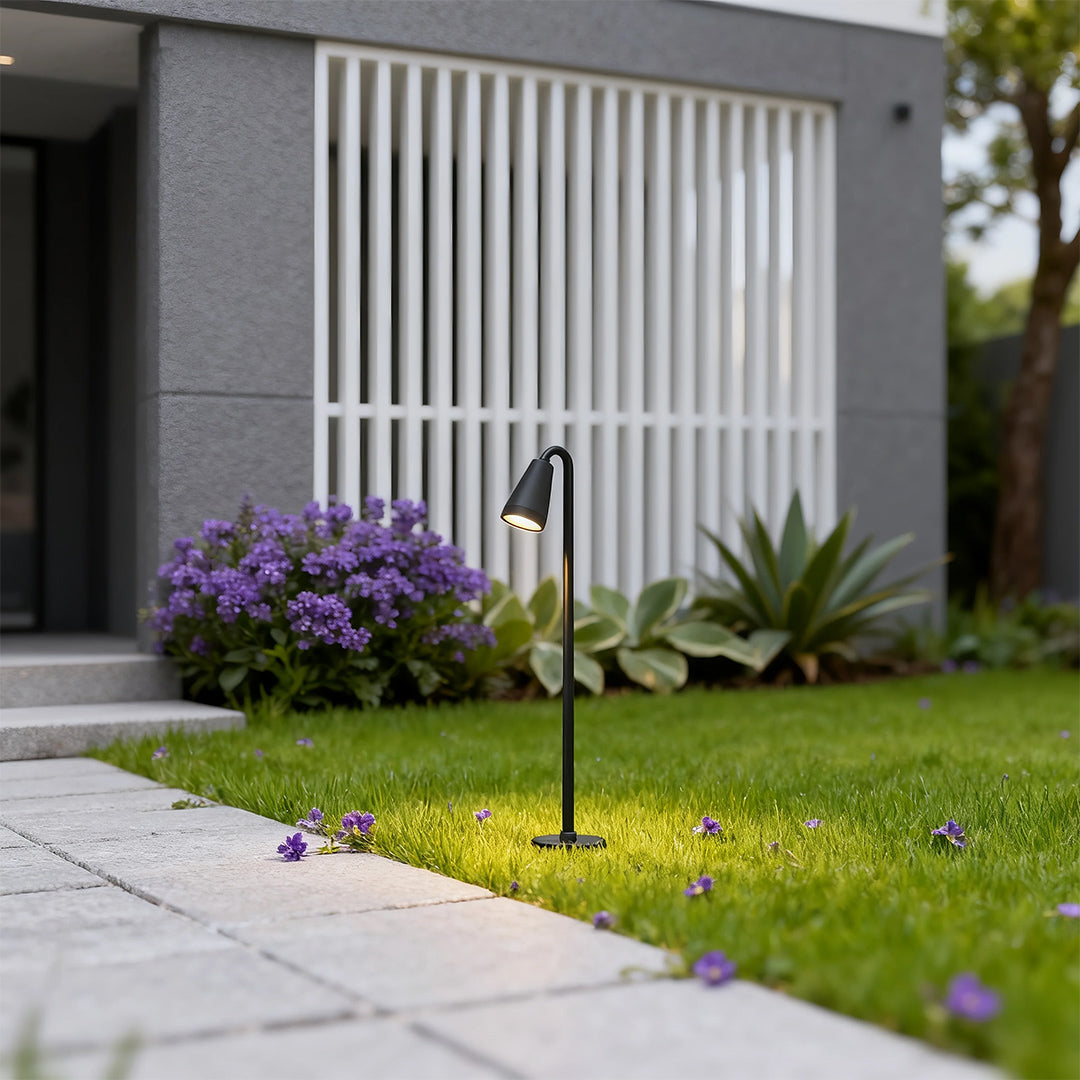 Landscape path light in a garden with cacti and rocks, adding a contemporary touch to the outdoor space.