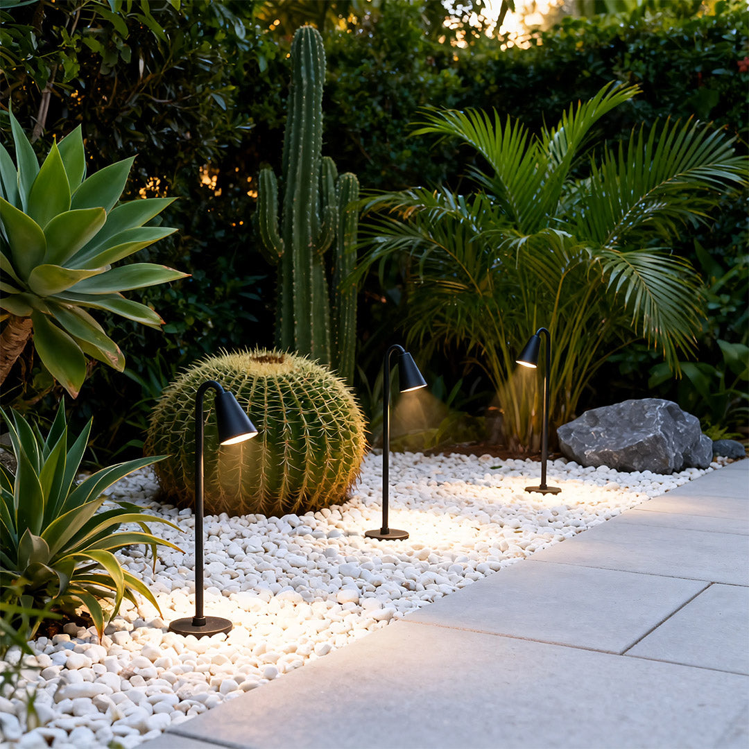 Landscape path light along a gravel pathway, providing subtle and elegant illumination.