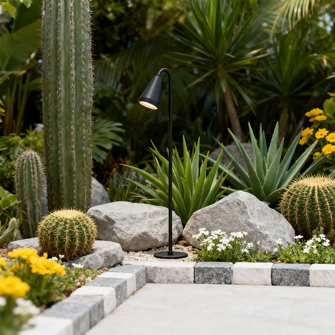 Landscape path light along a gravel pathway, providing subtle and elegant illumination.