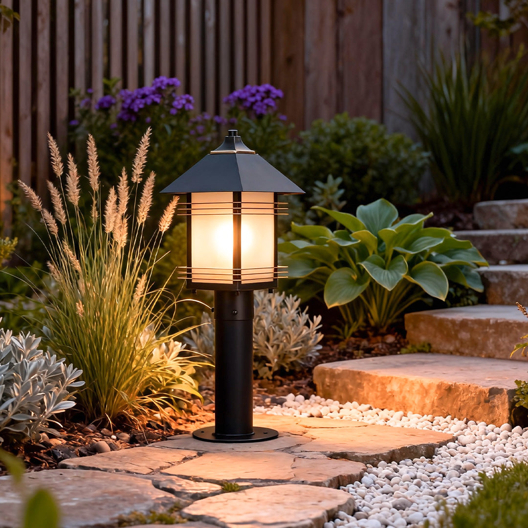Landscape path lighting fixtures illuminating plants and edging along a garden path, creating a welcoming nighttime atmosphere.