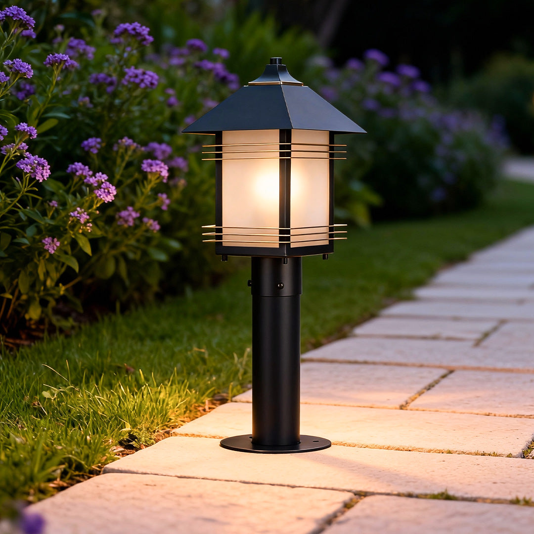 Landscape path lighting fixtures installed along a stone walkway, providing warm illumination for a landscaped garden path at night.